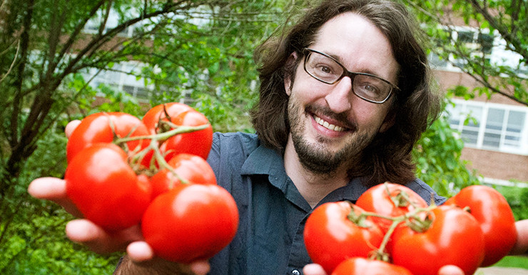 John Hoenig, doctoral candidate in Penn State's Department of History, holds ripe tomatoes.